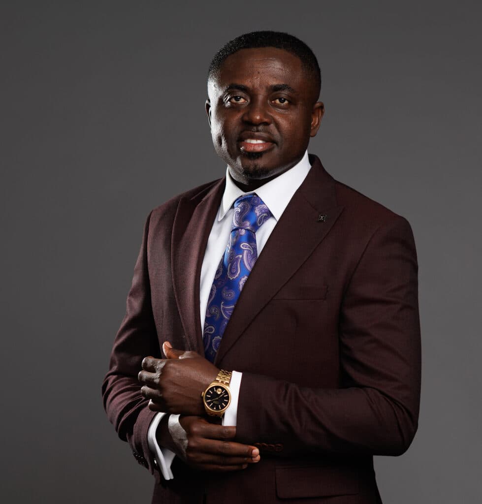 Reverend Prince Oppong Adjei in a burgundy suit and patterned tie